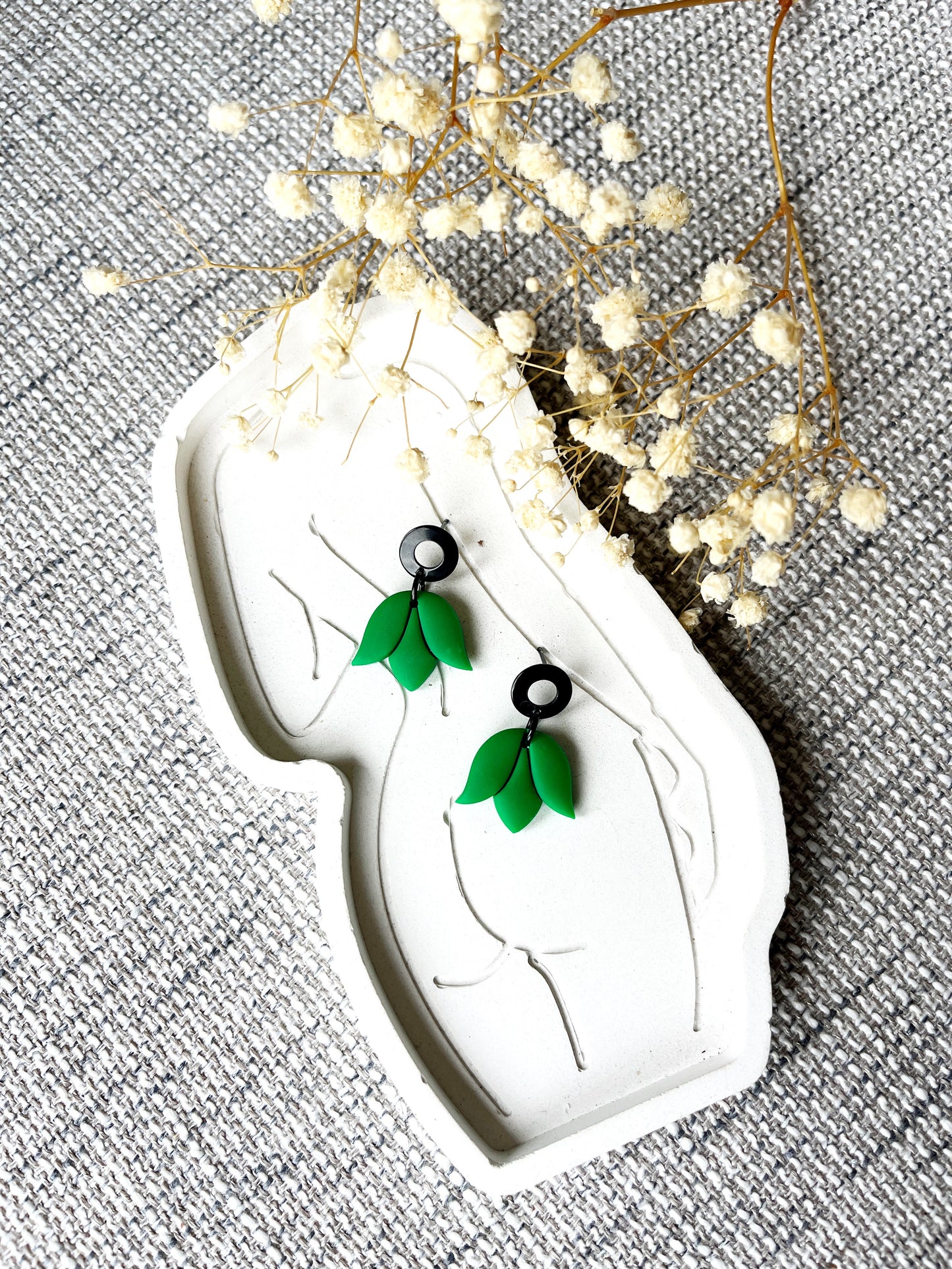 Black stud earring with delicate kelly green tulip design