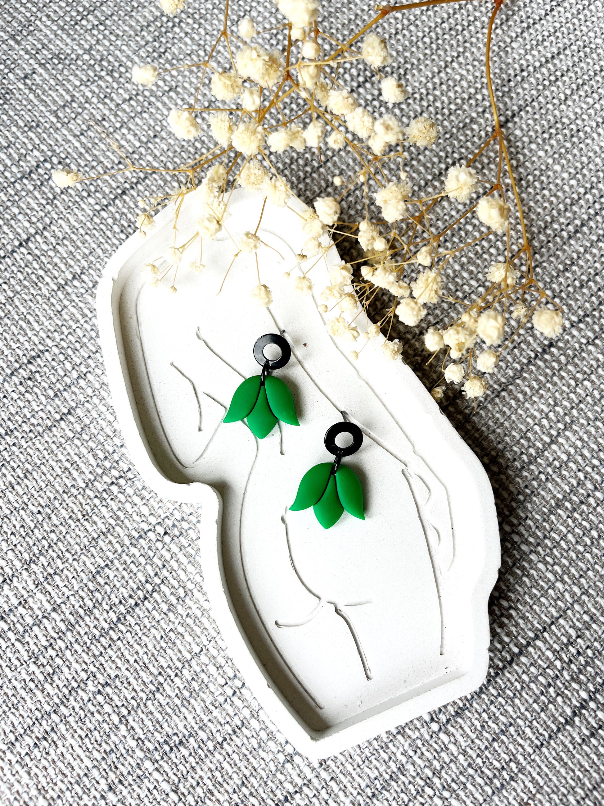 Black stud earring with delicate kelly green tulip design