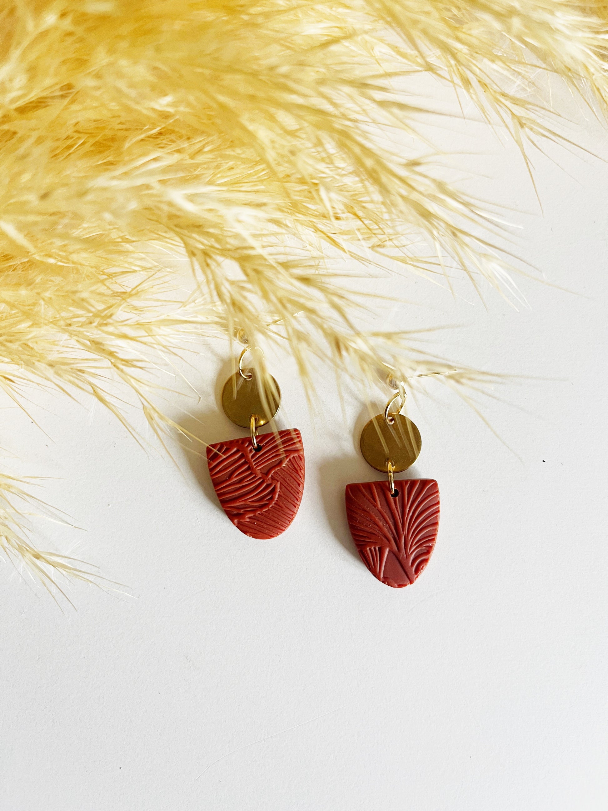 Gold stud earring with burnt orange textured inverted arch