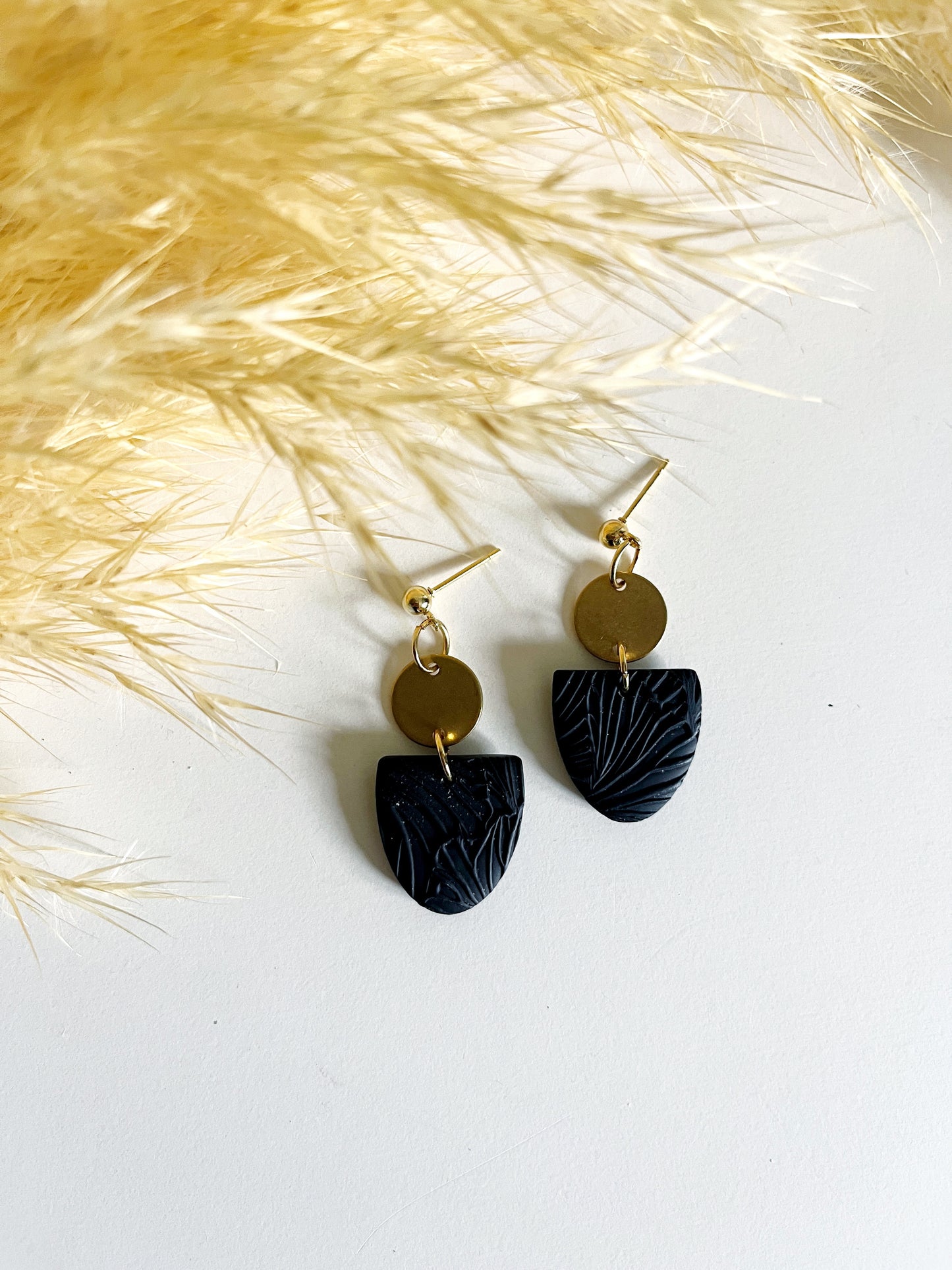 Gold stud earring with black textured inverted arch
