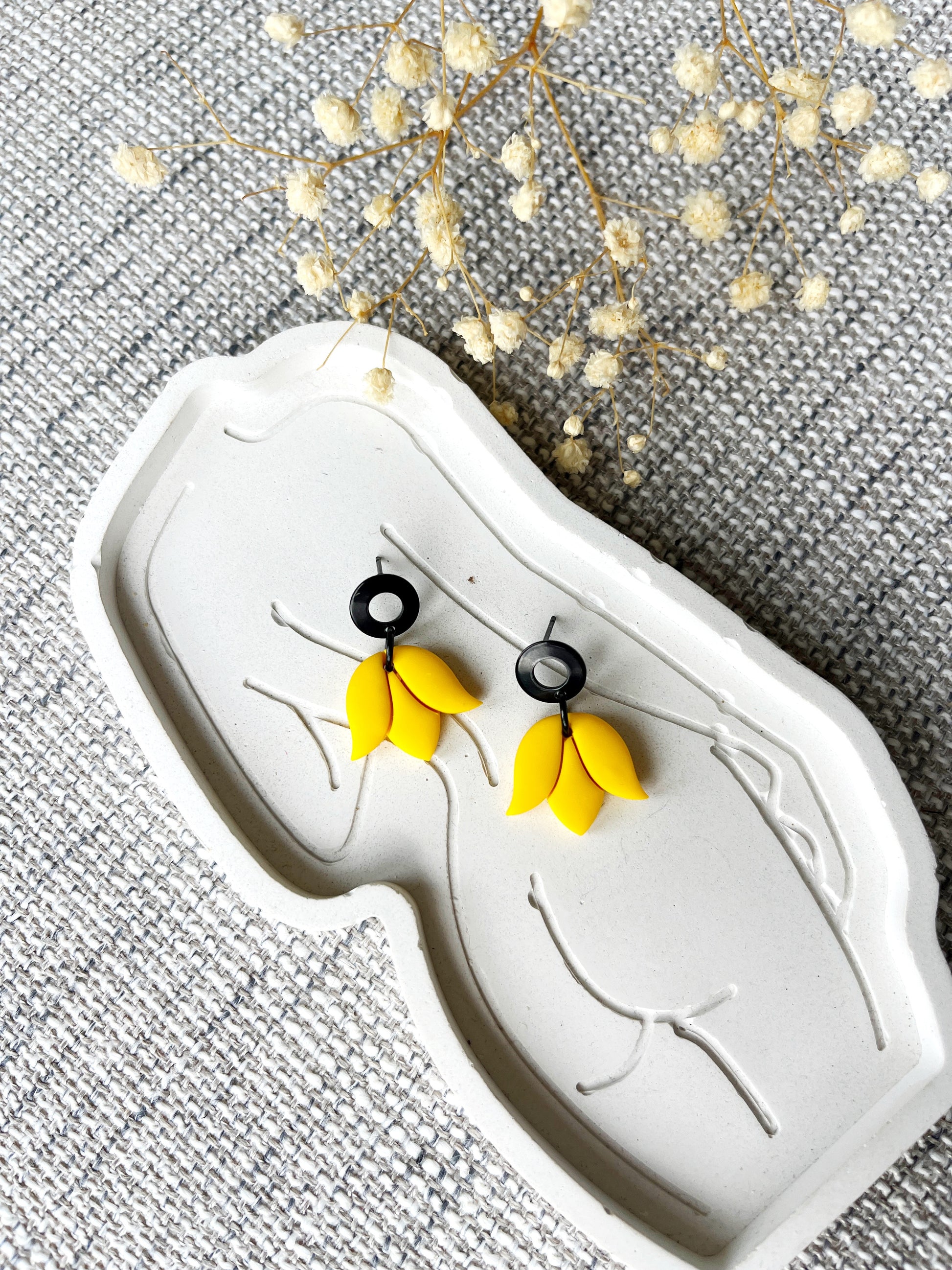 Black stud earring with delicate yellow tulip design