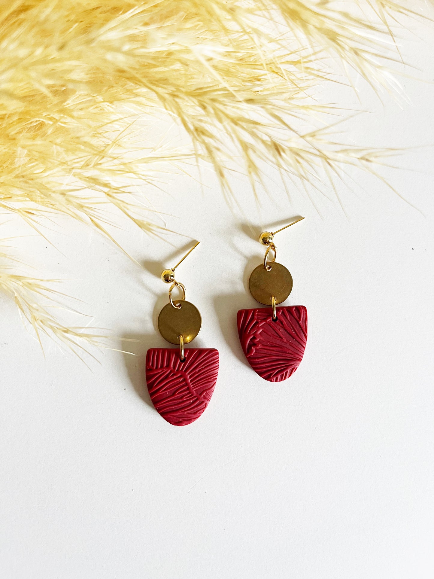 Gold stud earring with red textured inverted arch