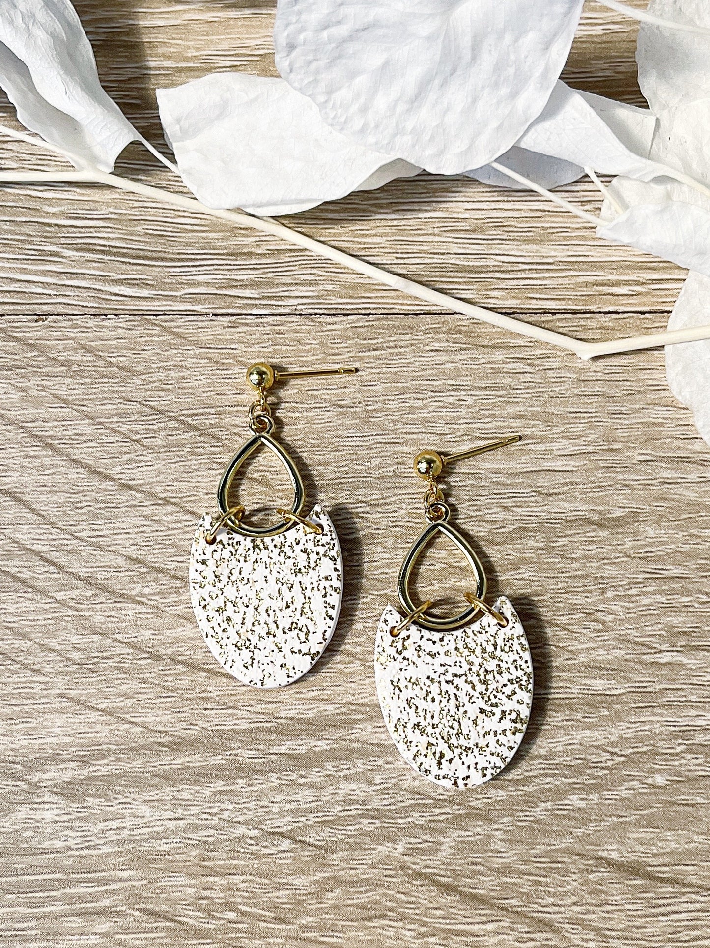 Gold stud earring with glittered white oval