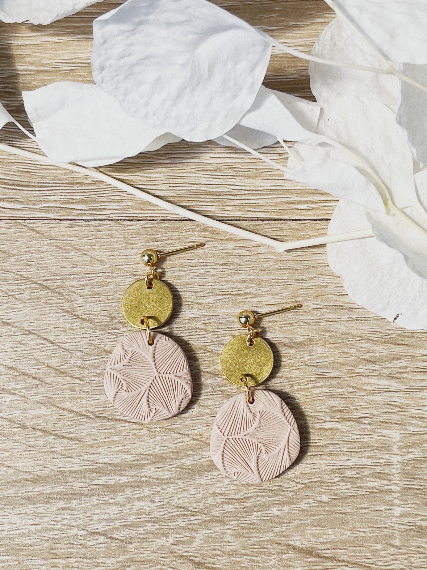 Gold stud earring with beige textured organic circle