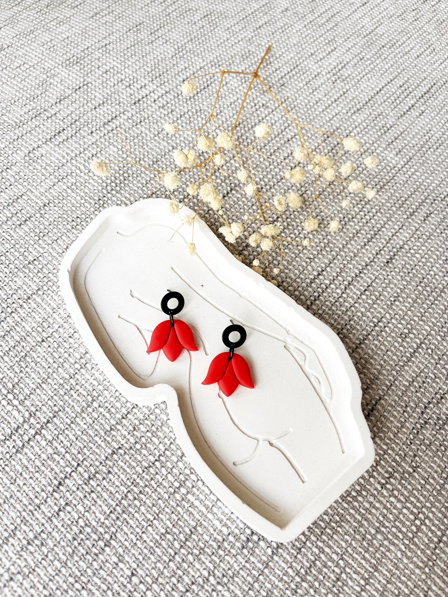 Black stud earring with delicate orange tulip design