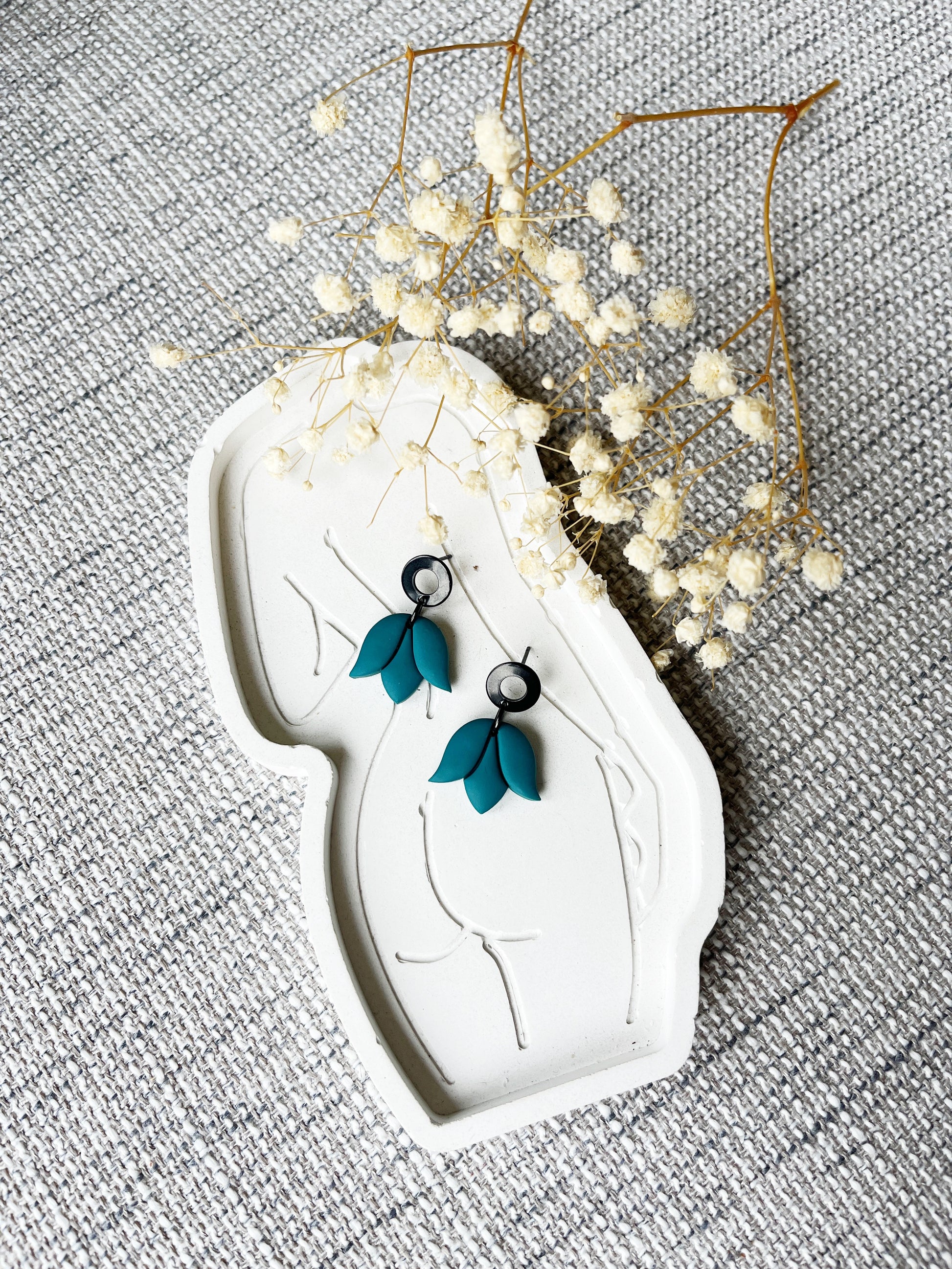 Black stud earring with delicate teal tulip design