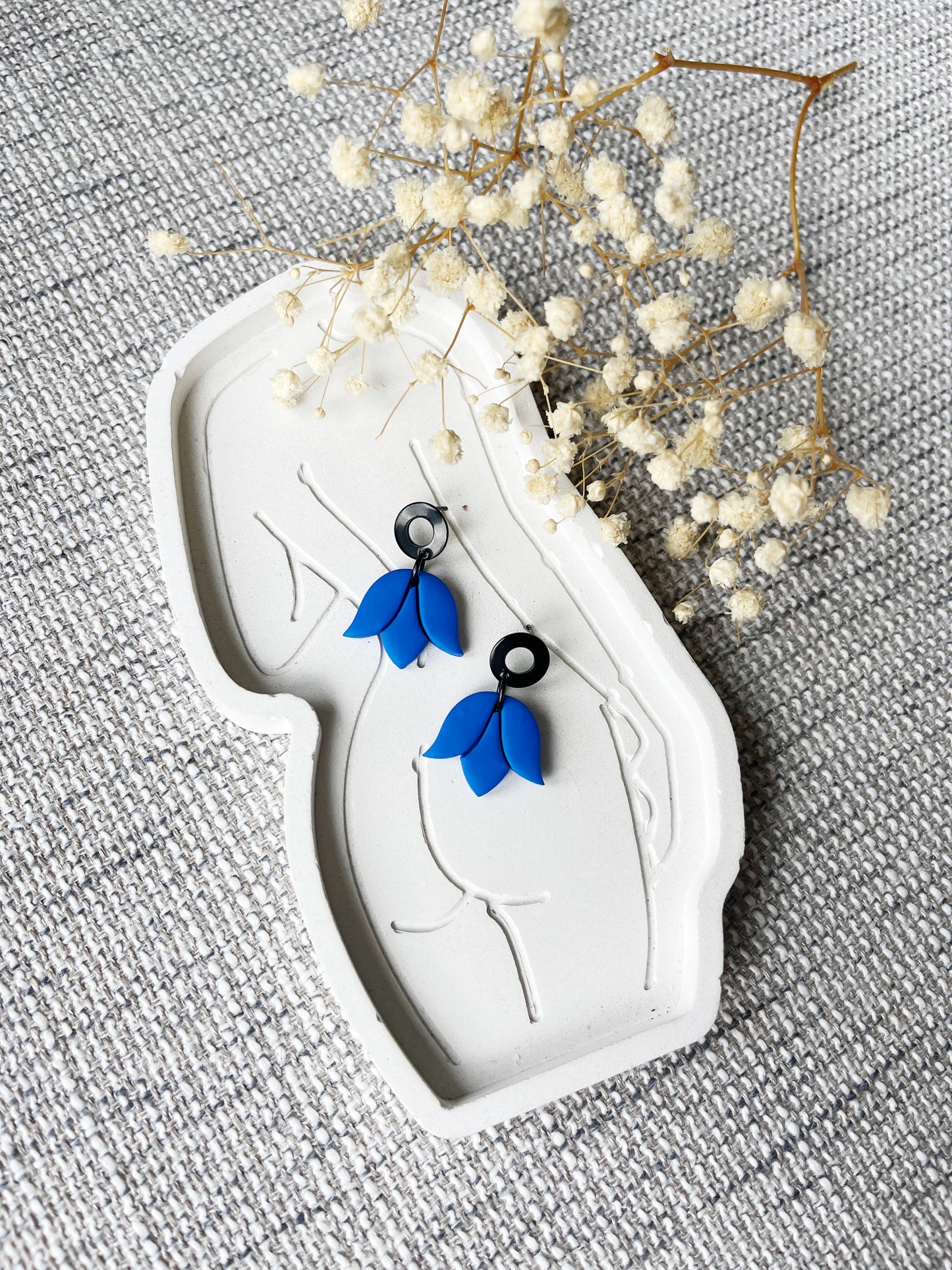 Black stud earring with delicate cobalt blue tulip design